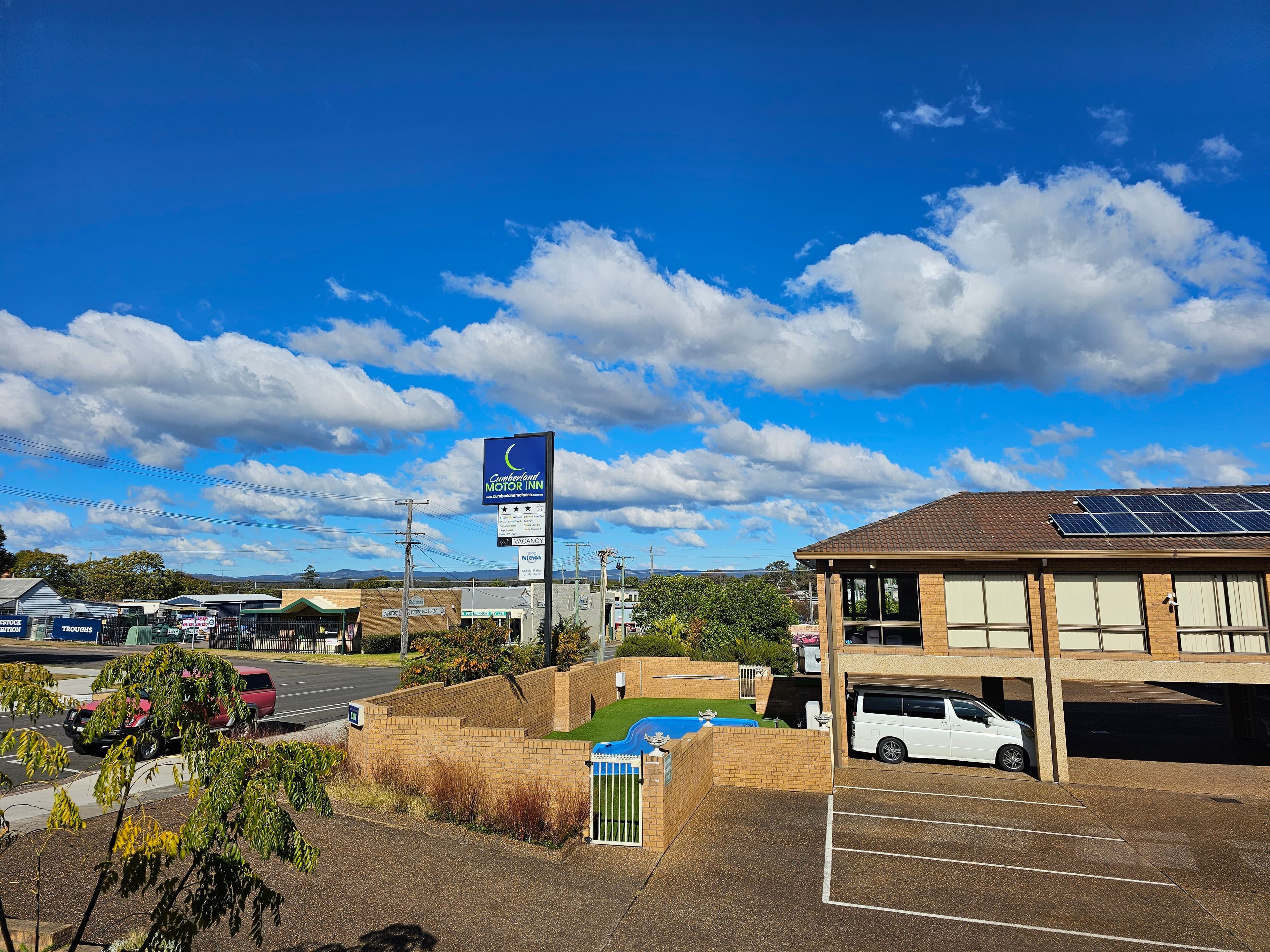 Cumberland Motor Inn grounds and outdoor pool beneath blue sky